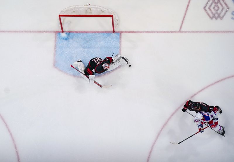 Mar 12, 2024; Raleigh, North Carolina, USA; Carolina Hurricanes goaltender Pyotr Kochetkov (52) makes the shot by New York Rangers center Jack Roslovic (96) during the first period at PNC Arena. Mandatory Credit: James Guillory-USA TODAY Sports