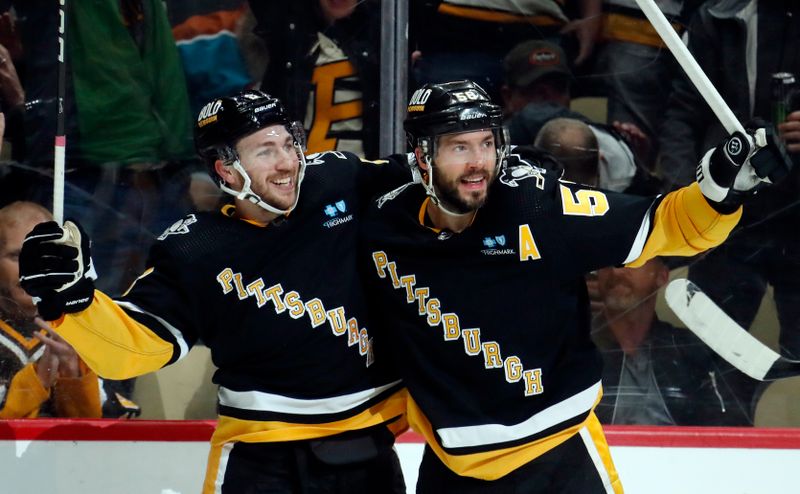 Apr 11, 2024; Pittsburgh, Pennsylvania, USA; Pittsburgh Penguins left wing Michael Bunting (8) and defenseman Kris Letang (58) celebrate a goal by Letang against the Detroit Red Wings during the first period at PPG Paints Arena. Mandatory Credit: Charles LeClaire-USA TODAY Sports