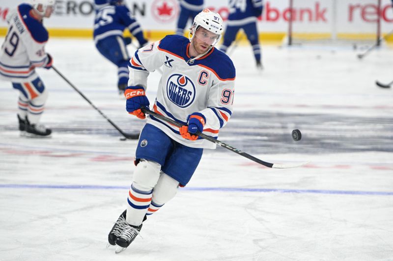 Nov 16, 2024; Toronto, Ontario, CAN;   Edmonton Oilers forward Connor McDavid (97) bounces a puck on his stick as he warms up before playing the Toronto Maple Leafs at Scotiabank Arena. Mandatory Credit: Dan Hamilton-Imagn Images