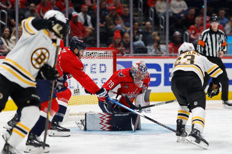 Oct 5, 2024; Washington, District of Columbia, USA; Washington Capitals goaltender Charlie Lindgren (79) makes a save on Boston Bruins left wing Brad Marchand (63) in the second period at Capital One Arena. Mandatory Credit: Geoff Burke-Imagn Images