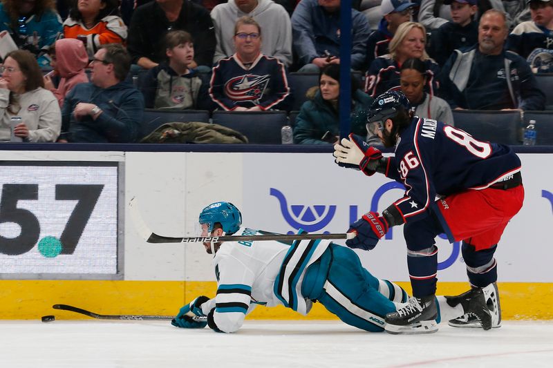 Mar 16, 2024; Columbus, Ohio, USA; San Jose Sharks defenseman Kyle Burroughs (4) falls to the ice after contact with Columbus Blue Jackets right wing Kirill Marchenko (86) during the third period at Nationwide Arena. Mandatory Credit: Russell LaBounty-USA TODAY Sports