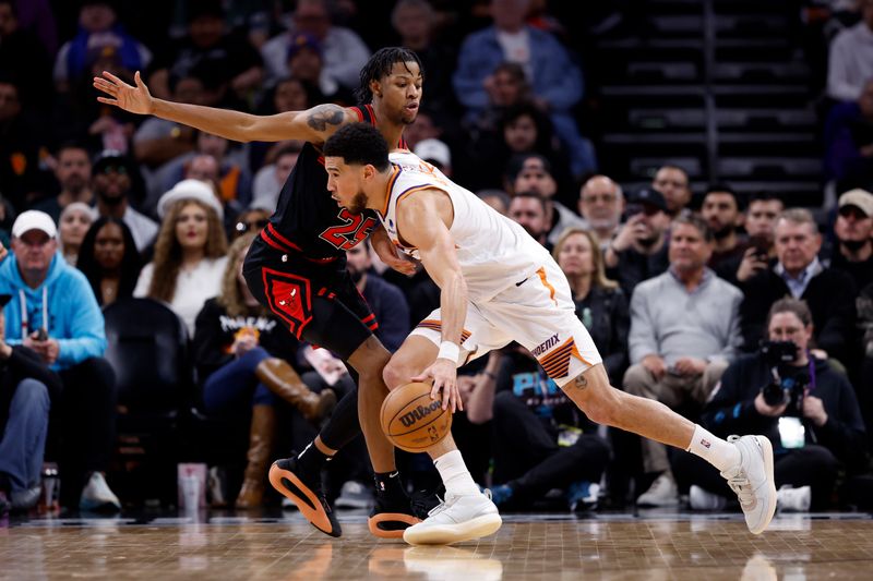 PHOENIX, ARIZONA - JANUARY 22: Devin Booker #1 of the Phoenix Suns drives against Dalen Terry #25 of the Chicago Bulls during the second half at Footprint Center on January 22, 2024 in Phoenix, Arizona. NOTE TO USER: User expressly acknowledges and agrees that, by downloading and or using this photograph, User is consenting to the terms and conditions of the Getty Images License Agreement.  (Photo by Chris Coduto/Getty Images)