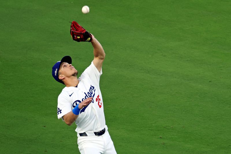Oct 20, 2024; Los Angeles, California, USA; Los Angeles Dodgers outfielder Tommy Edman (25) catches a fly ball during the second inning against the New York Mets during game six of the NLCS for the 2024 MLB playoffs at Dodger Stadium. Mandatory Credit: Kiyoshi Mio-Imagn Images