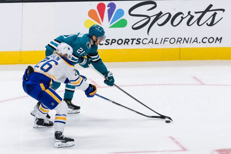 Nov 23, 2024; San Jose, California, USA; Buffalo Sabres defenseman Rasmus Dahlin (26) and San Jose Sharks center Alexander Wennberg (21) battle for possession during the third period at SAP Center in San Jose. Mandatory Credit: John Hefti-Imagn Images