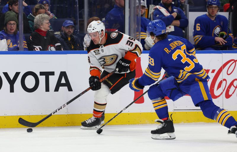 Feb 19, 2024; Buffalo, New York, USA;  Anaheim Ducks center Sam Carrick (39) controls the puck as Buffalo Sabres defenseman Ryan Johnson (33) defends during the third period at KeyBank Center. Mandatory Credit: Timothy T. Ludwig-USA TODAY Sports