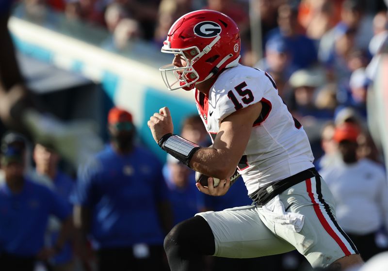 Oct 28, 2023; Jacksonville, Florida, USA; Georgia Bulldogs quarterback Carson Beck (15) runs the ball against the Florida Gators during the first half at EverBank Stadium. Mandatory Credit: Kim Klement Neitzel-USA TODAY Sports