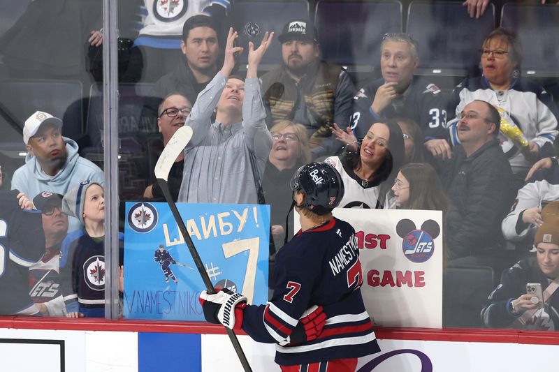 Mar 23, 2025; Winnipeg, Manitoba, CAN; Winnipeg Jets center Vladislav Namestnikov (7) tosses a puck to fans before a game against the Buffalo Sabres at Canada Life Centre. Mandatory Credit: James Carey Lauder-Imagn Images