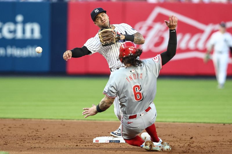 Jul 3, 2024; Bronx, New York, USA; New York Yankees second baseman Gleyber Torres (25) throws past Cincinnati Reds second baseman Jonathan India (6) attempting to complete a double play in the third inning at Yankee Stadium. Mandatory Credit: Wendell Cruz-USA TODAY Sports