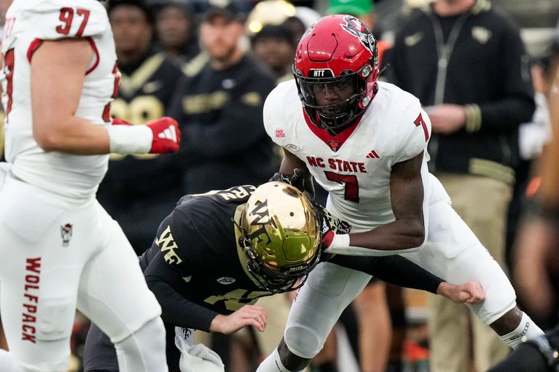 Nov 11, 2023; Winston-Salem, North Carolina, USA; Wake Forest Demon Deacons quarterback Michael Kern (15) is blocked by North Carolina State Wolfpack cornerback Shyheim Battle (7) after he throws an interception during the second half at Allegacy Federal Credit Union Stadium. Mandatory Credit: Jim Dedmon-USA TODAY Sports