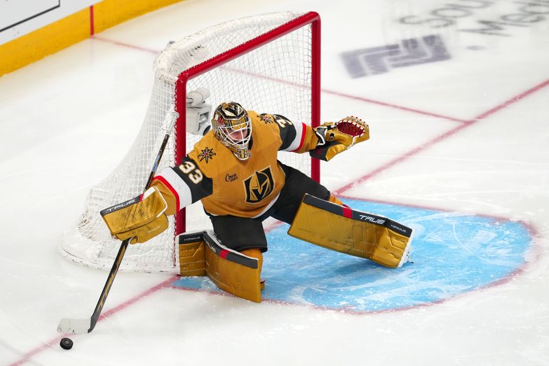 Apr 14, 2024; Las Vegas, Nevada, USA; Vegas Golden Knights goaltender Adin Hill (33) slows a dump in by the Colorado Avalanche during the third period at T-Mobile Arena. Mandatory Credit: Stephen R. Sylvanie-USA TODAY Sports