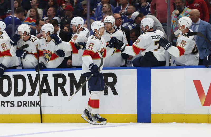 Apr 30, 2025; Tampa, Florida, USA; Florida Panthers center Eetu Luostarinen (27) is congratulated  after he scored a goal against the Tampa Bay Lightning during the third period of game five of the first round of the 2025 Stanley Cup Playoffs at Amalie Arena. Mandatory Credit: Kim Klement Neitzel-Imagn Images