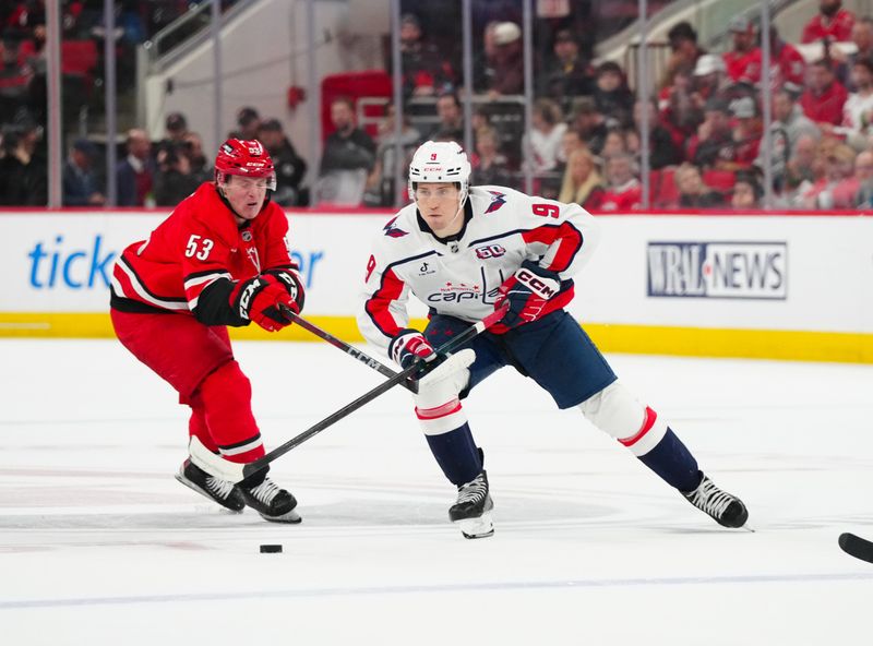 Apr 2, 2025; Raleigh, North Carolina, USA;  Washington Capitals right wing Ryan Leonard (9) skates with the puck past Carolina Hurricanes right wing Jackson Blake (53) during the second period at Lenovo Center. Mandatory Credit: James Guillory-Imagn Images