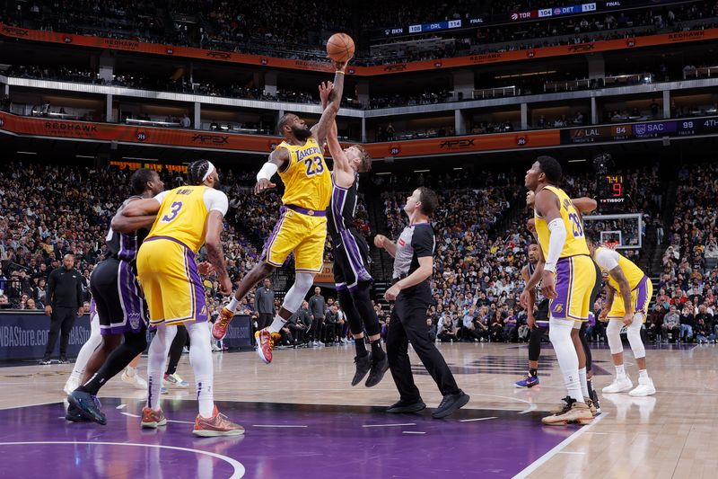 SACRAMENTO, CA - MARCH 13:  LeBron James #23 of the Los Angeles Lakers and Domantas Sabonis #10 of the Sacramento Kings go up for a tip off on March 13, 2024 at Golden 1 Center in Sacramento, California. NOTE TO USER: User expressly acknowledges and agrees that, by downloading and or using this Photograph, user is consenting to the terms and conditions of the Getty Images License Agreement. Mandatory Copyright Notice: Copyright 2024 NBAE (Photo by Rocky Widner/NBAE via Getty Images)