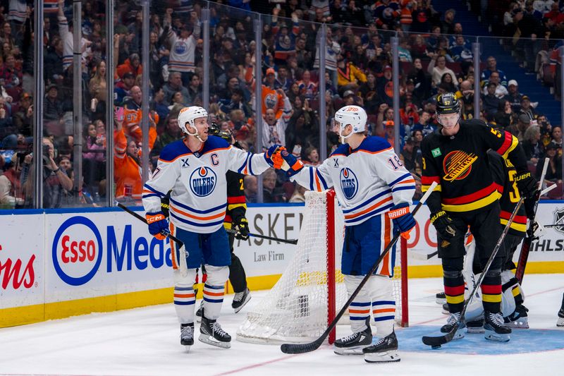 Nov 9, 2024; Vancouver, British Columbia, CAN; Edmonton Oilers forward Connor McDavid (97) celebrates with forward Zach Hyman (18) after scoring a goal against the Vancouver Canucks during the third period at Rogers Arena. Mandatory Credit: Bob Frid-Imagn Images