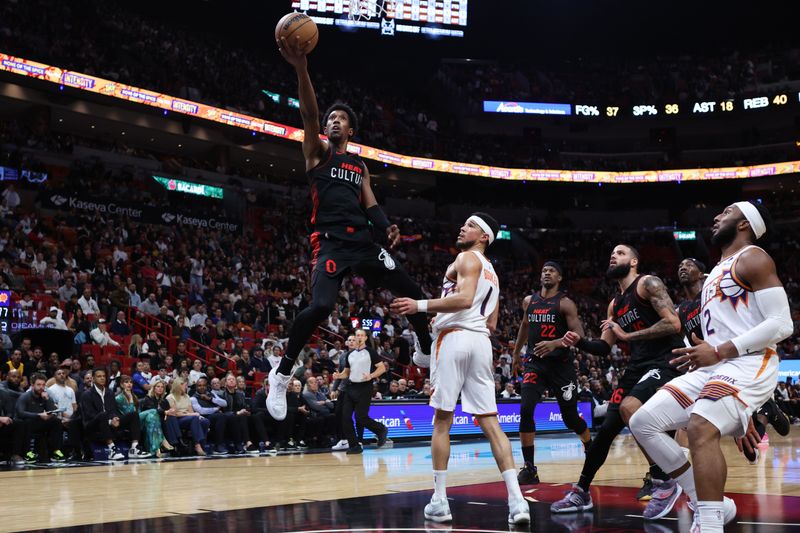 MIAMI, FLORIDA - JANUARY 29: Josh Richardson #0 of the Miami Heat drives to the basket past Devin Booker #1 of the Phoenix Suns during the fourth quarter of the game at Kaseya Center on January 29, 2024 in Miami, Florida. NOTE TO USER: User expressly acknowledges and agrees that, by downloading and or using this photograph, User is consenting to the terms and conditions of the Getty Images License Agreement. (Photo by Megan Briggs/Getty Images)