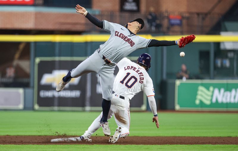 May 1, 2024; Houston, Texas, USA;  Houston Astros left fielder Joey Loperfido (10) is safe at second base as Cleveland Guardians second baseman Andres Gimenez (0) is unable to field a throw during the third inning at Minute Maid Park. Mandatory Credit: Troy Taormina-USA TODAY Sports