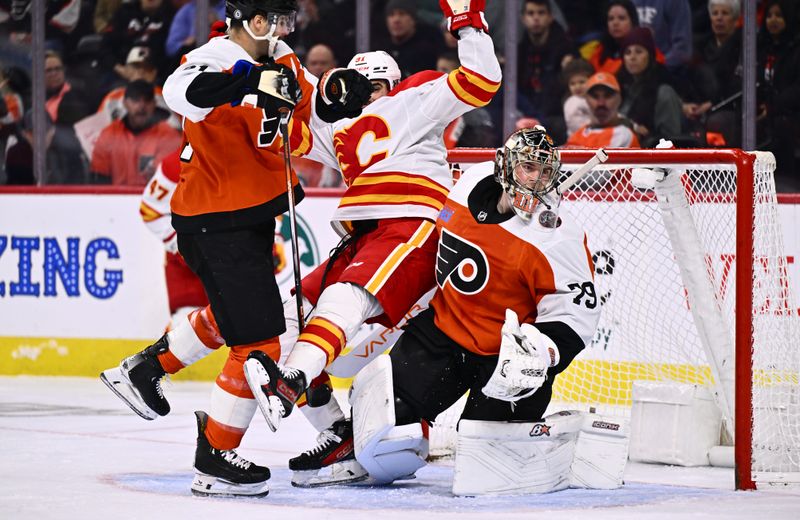 Jan 6, 2024; Philadelphia, Pennsylvania, USA; Philadelphia Flyers center Scott Laughton (21) hits Calgary Flames center Nazem Kadri (91) into Philadelphia Flyers goalie Carter Hart (79) in the first period at Wells Fargo Center. Mandatory Credit: Kyle Ross-USA TODAY Sports