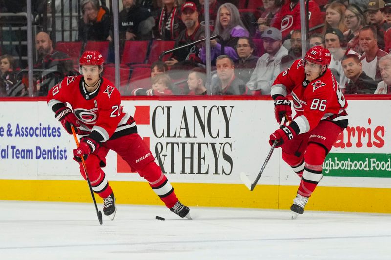 Jan 31, 2023; Raleigh, North Carolina, USA; Carolina Hurricanes left wing Teuvo Teravainen (86) and center Sebastian Aho (20) skate up the ice against the Los Angeles Kings during the first period at PNC Arena. Mandatory Credit: James Guillory-USA TODAY Sports