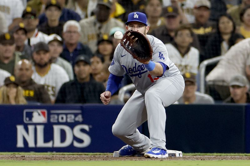 Oct 9, 2024; San Diego, California, USA; Los Angeles Dodgers third baseman Max Muncy (13) makes an out at first in the second inning against the San Diego Padres during game four of the NLDS for the 2024 MLB Playoffs at Petco Park. Mandatory Credit: David Frerker-Imagn Images