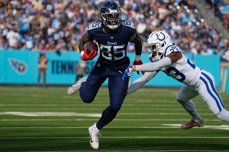 Tennessee Titans tight end Chigoziem Okonkwo (85) runs after a catch past Indianapolis Colts cornerback Kenny Moore II (23) during the first half of an NFL football game Sunday, Dec. 3, 2023, in Nashville, Tenn. (AP Photo/George Walker IV)