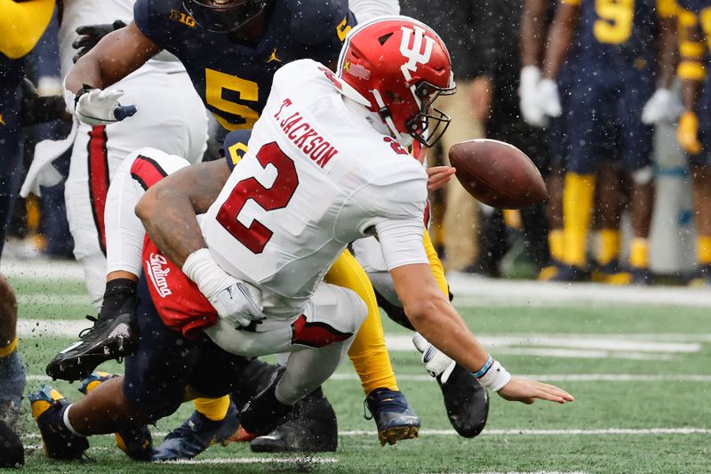 Oct 14, 2023; Ann Arbor, Michigan, USA; Indiana Hoosiers quarterback Tayven Jackson (2) fumbles as he is sacked by Michigan Wolverines linebacker Michael Barrett (23) and defensive end Josaiah Stewart (5) in the second half against the Michigan Wolverines at Michigan Stadium. Mandatory Credit: Rick Osentoski-USA TODAY Sports