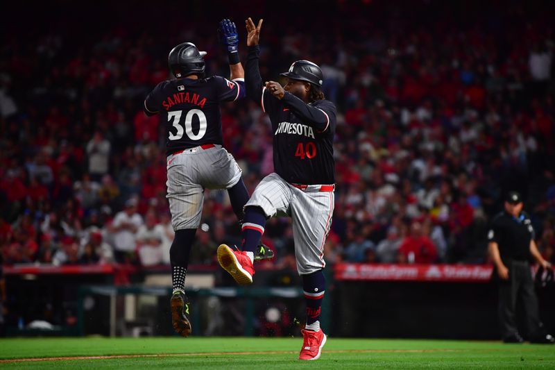 Apr 27, 2024; Anaheim, California, USA;  Minnesota Twins first baseman Carlos Santana (30) is greeted by third base coach/outfield coach Tommy Watkins (40) after hitting a three run home run against the Los Angeles Angels during the fourth inning at Angel Stadium. Mandatory Credit: Gary A. Vasquez-USA TODAY Sports