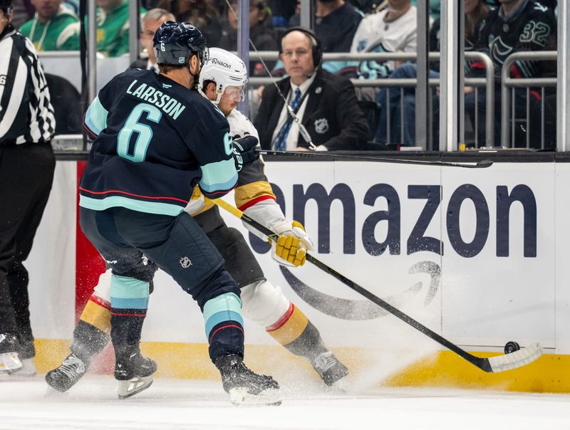 Oct 11, 2025; Seattle, Washington, USA; Seattle Kraken defenseman Adam Larsson (6) and Vegas Golden Knights defenseman Kaedan Korczak (6) battle for the puck during the first period at Climate Pledge Arena. Mandatory Credit: Stephen Brashear-Imagn Images