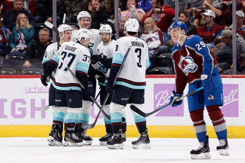 Nov 9, 2023; Denver, Colorado, USA; Seattle Kraken right wing Oliver Bjorkstrand (22) celebrates his goal with center Yanni Gourde (37) and right wing Eeli Tolvanen (20) and defenseman Jamie Oleksiak (24) and defenseman Will Borgen (3) as Colorado Avalanche center Nathan MacKinnon (29) skates by in the second period at Ball Arena. Mandatory Credit: Isaiah J. Downing-USA TODAY Sports