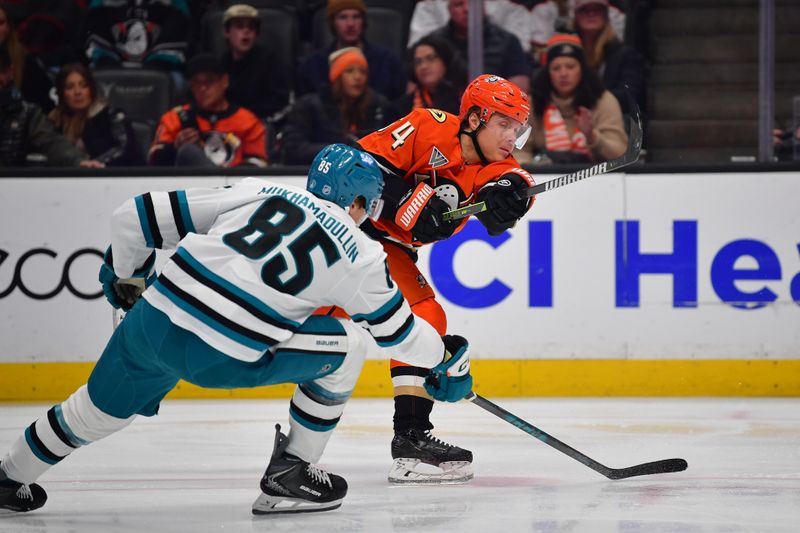 Dec 29, 2025; Anaheim, California, USA; Anaheim Ducks center Mikael Granlund (64) shoots against the defense of San Jose Sharks defenseman Shakir Mukhamadullin (85) during the second period at Honda Center. Mandatory Credit: Gary A. Vasquez-Imagn Images