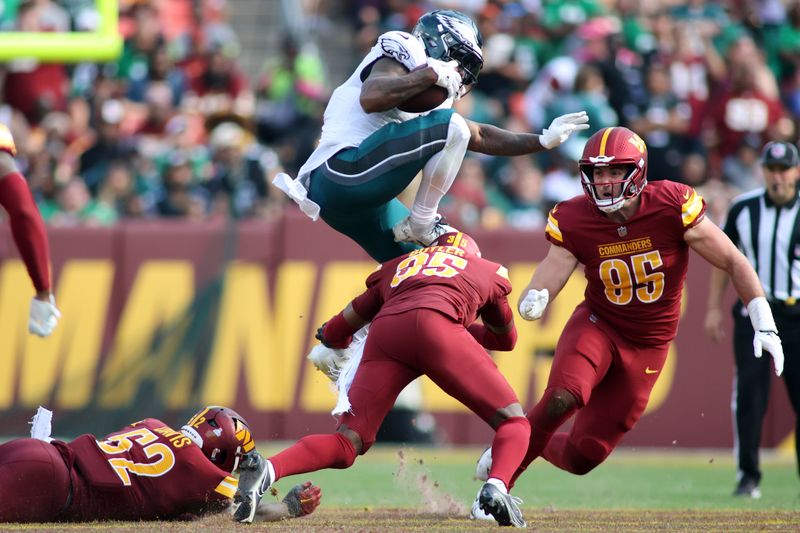Philadelphia Eagles running back D'Andre Swift (0) leaps over Washington Commanders safety Percy Butler (35)during an NFL football game, Sunday, October 29, 2023 in Landover, Maryland. (AP Photo/Daniel Kucin Jr.)