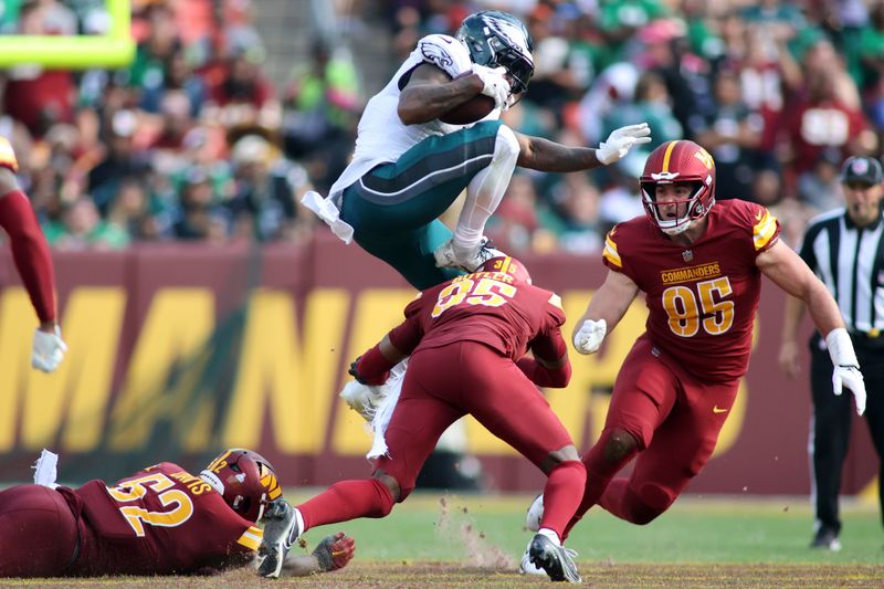 Philadelphia Eagles running back D'Andre Swift (0) leaps over Washington Commanders safety Percy Butler (35)during an NFL football game, Sunday, October 29, 2023 in Landover, Maryland. (AP Photo/Daniel Kucin Jr.)