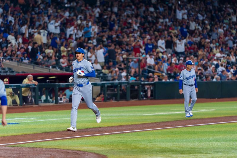 Aug 30, 2024; Phoenix, Arizona, USA;  Los Angeles Dodgers designated hitter Shohei Ohtani (17) scores after  third baseman Freddie Freeman (5) (not shown) hits a home run in the first inning during a game against the Arizona Diamondbacks at Chase Field. Mandatory Credit: Allan Henry-USA TODAY Sports