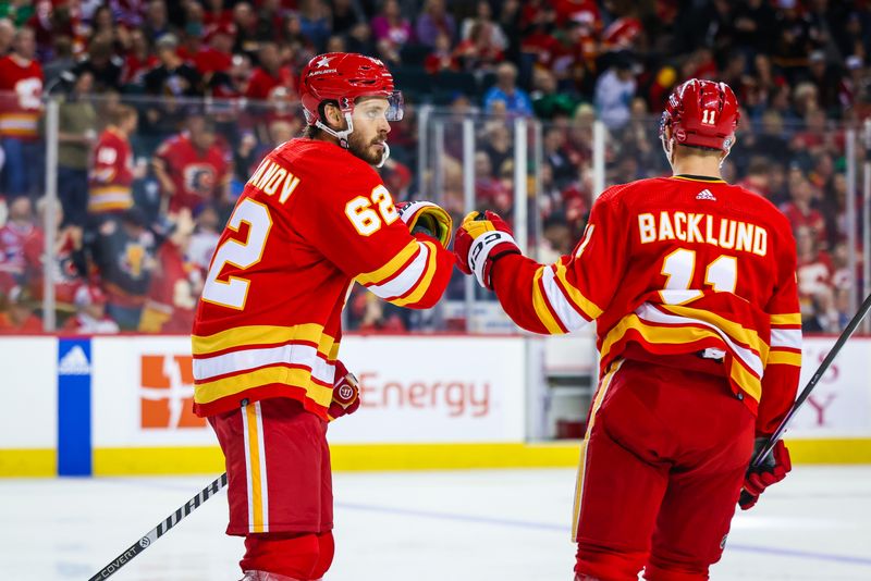 Mar 16, 2024; Calgary, Alberta, CAN; Calgary Flames defenseman Daniil Miromanov (62) celebrates his goal with center Mikael Backlund (11) during the third period against the Montreal Canadiens at Scotiabank Saddledome. Mandatory Credit: Sergei Belski-USA TODAY Sports