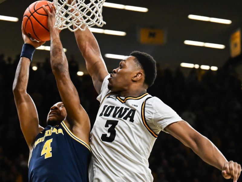 Mar 5, 2026; Iowa City, Iowa, USA; Iowa Hawkeyes forward Cam Manyawu (3) blocks the shot of Michigan Wolverines guard Nimari Burnett (4) during the first half at Carver-Hawkeye Arena. Mandatory Credit: Jeffrey Becker-Imagn Images