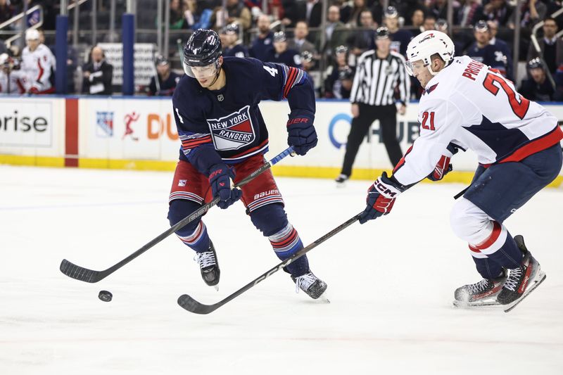 Mar 5, 2025; New York, New York, USA;  New York Rangers defenseman Braden Schneider (4) and Washington Capitals center Aliaksei Protas (21) chase after the puck in the second period at Madison Square Garden. Mandatory Credit: Wendell Cruz-Imagn Images