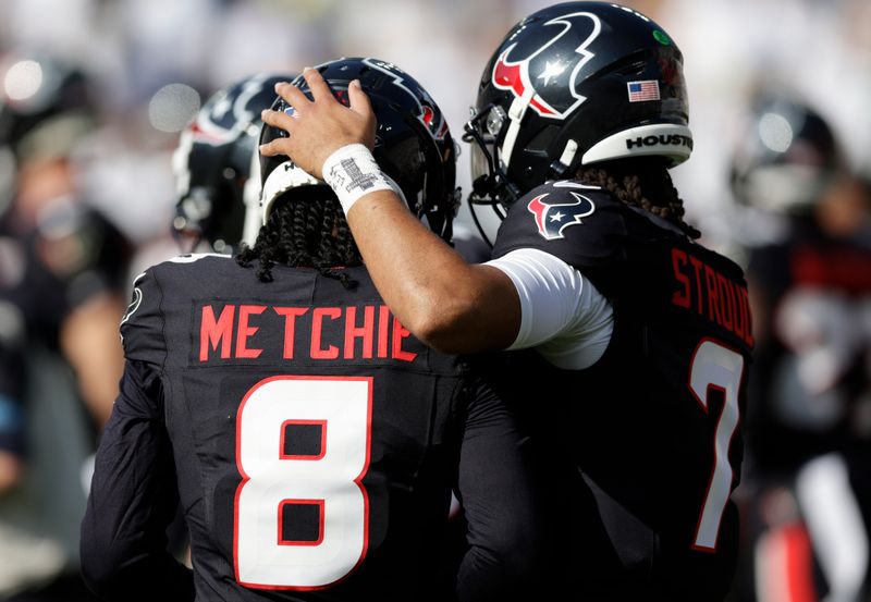 Houston Texans wide receiver John Metchie III (8) talks with quarterback C.J. Stroud (7) during warm-ups before an NFL football game against the Green Bay Packers, Sunday, Oct. 20, 2024, in Green Bay, Wis. (AP Photo/Matt Ludtke)