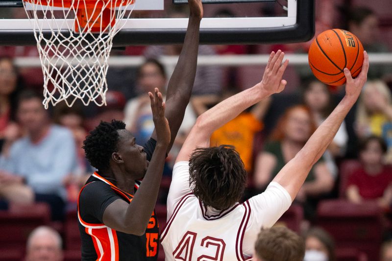 Feb 24, 2024; Stanford, California, USA; Oregon State Beavers center Chol Marial (15) tries to block a shot by Stanford Cardinal forward Maxime Raynaud (42) during the first half at Maples Pavilion. Mandatory Credit: D. Ross Cameron-USA TODAY Sports