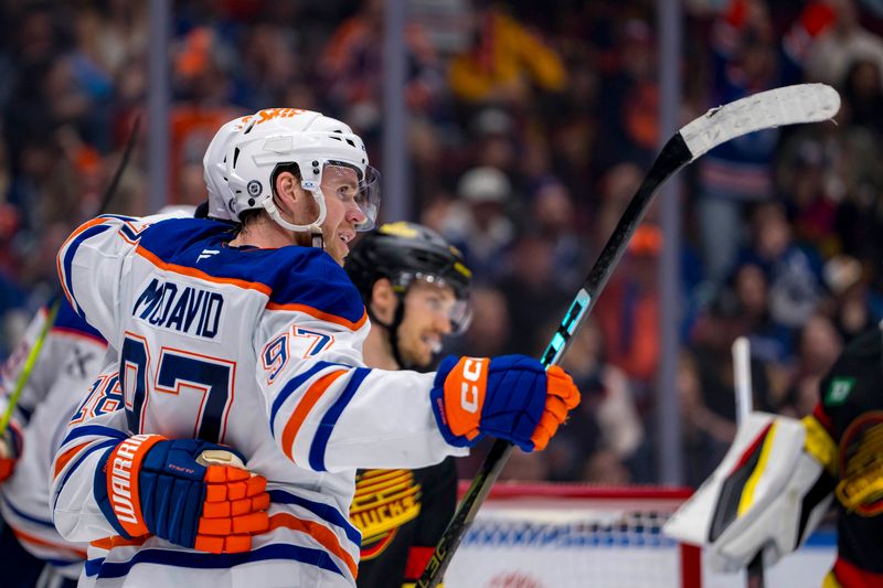 Nov 9, 2024; Vancouver, British Columbia, CAN; Edmonton Oilers forward Connor McDavid (97) celebrates with forward Zach Hyman (18) after scoring a goal against the Vancouver Canucks during the third period at Rogers Arena. Mandatory Credit: Bob Frid-Imagn Images