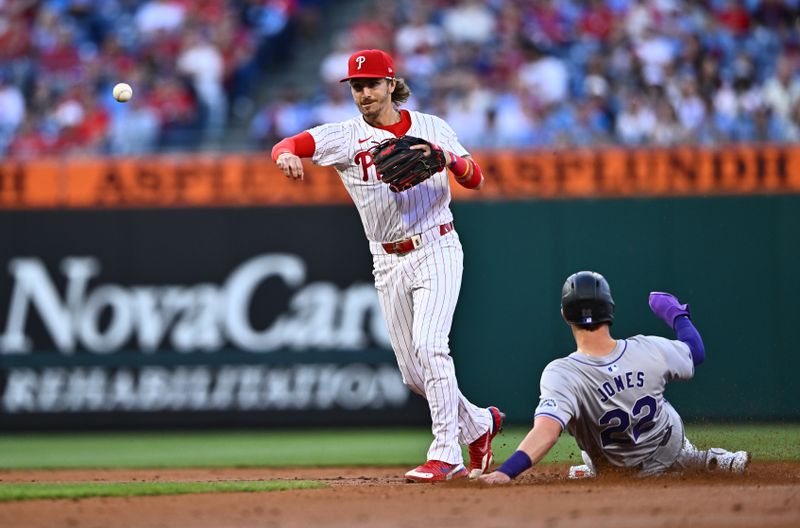 Apr 16, 2024; Philadelphia, Pennsylvania, USA; Philadelphia Phillies second baseman Bryson Stott (5) turns a double play over Colorado Rockies outfielder Nolan Jones (22) in the second inning at Citizens Bank Park. Mandatory Credit: Kyle Ross-USA TODAY Sports