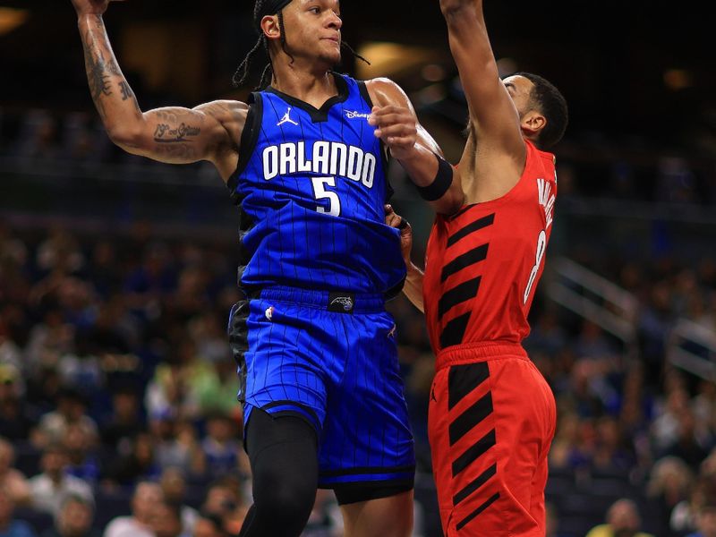 ORLANDO, FLORIDA - APRIL 01: Paolo Banchero #5 of the Orlando Magic passes over Kris Murray #8 of the Portland Trail Blazers during a game  at Kia Center on April 01, 2024 in Orlando, Florida. NOTE TO USER: User expressly acknowledges and agrees that, by downloading and or using this photograph, User is consenting to the terms and conditions of the Getty Images License Agreement. (Photo by Mike Ehrmann/Getty Images)