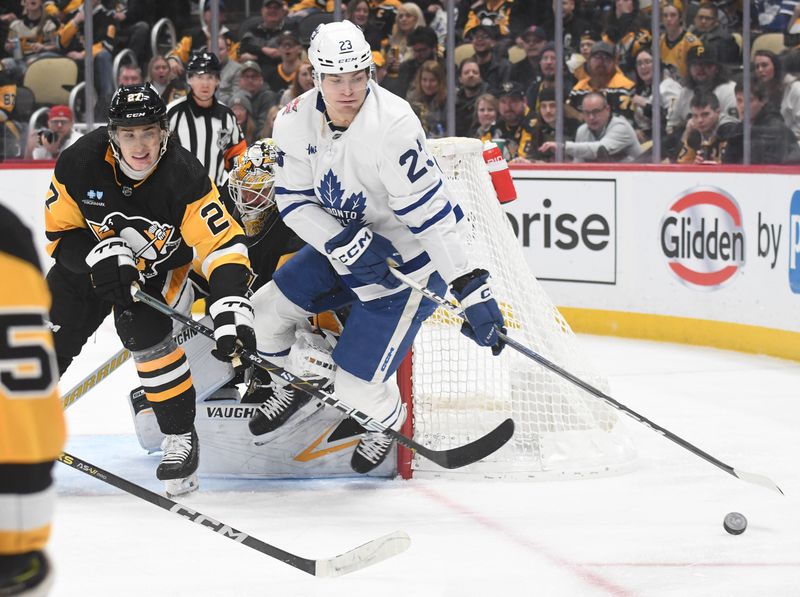 Nov 25, 2023; Pittsburgh, Pennsylvania, USA;Toronto Maple Leafs left wingMatthew Knies (23) keeps the puck from Pittsburgh Penguins defenseman Ryan Graves (27) during the second period at PPG Paints Arena. Mandatory Credit: Philip G. Pavely-USA TODAY Sports