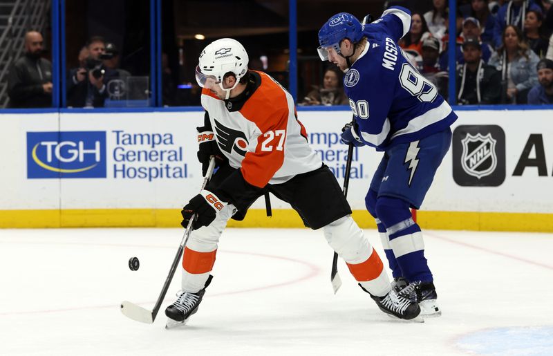 Mar 17, 2025; Tampa, Florida, USA;  Philadelphia Flyers left wing Noah Cates (27) skates with the puck as Tampa Bay Lightning defenseman J.J. Moser (90) defends during the second period at Amalie Arena. Mandatory Credit: Kim Klement Neitzel-Imagn Images