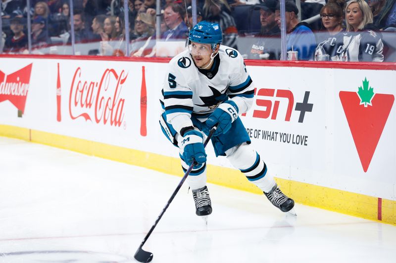 Oct 18, 2024; Winnipeg, Manitoba, CAN;  San Jose Sharks defenseman Matt Benning (5) looks to make a pass against the Winnipeg Jets during the second period at Canada Life Centre. Mandatory Credit: Terrence Lee-Imagn Images