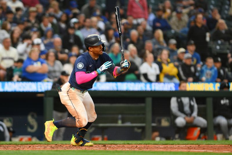 Jun 11, 2024; Seattle, Washington, USA; Seattle Mariners center fielder Julio Rodriguez (44) hits a single against the Chicago White Sox during the seventh inning at T-Mobile Park. Mandatory Credit: Steven Bisig-USA TODAY Sports