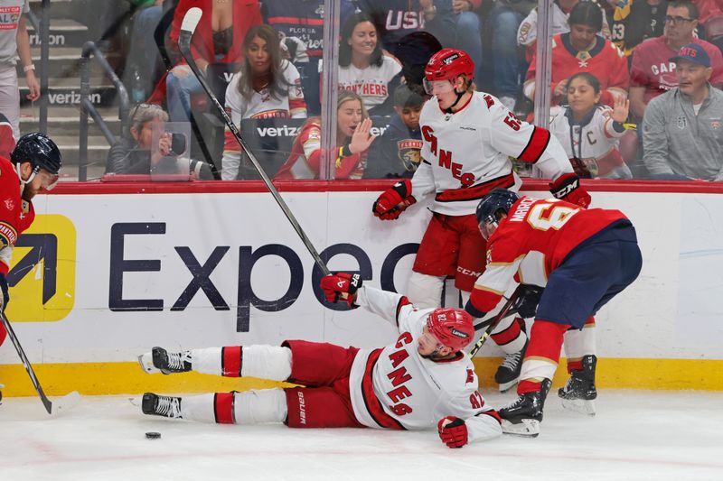 May 24, 2025; Sunrise, Florida, USA; Florida Panthers center Brad Marchand (63) and Carolina Hurricanes center Jesperi Kotkaniemi (82) battle for the puck as Carolina Hurricanes right wing Jackson Blake (53) defends during the second period in game three of the Eastern Conference Final of the 2025 Stanley Cup Playoffs at Amerant Bank Arena. Mandatory Credit: Sam Navarro-Imagn Images