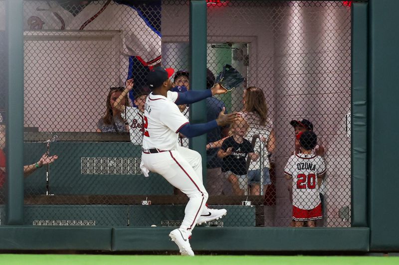 Sep 3, 2024; Atlanta, Georgia, USA; Atlanta Braves right fielder Jorge Soler (2) reaches for a ball at the wall against the Colorado Rockies in the sixth inning at Truist Park. Mandatory Credit: Brett Davis-Imagn Images 
