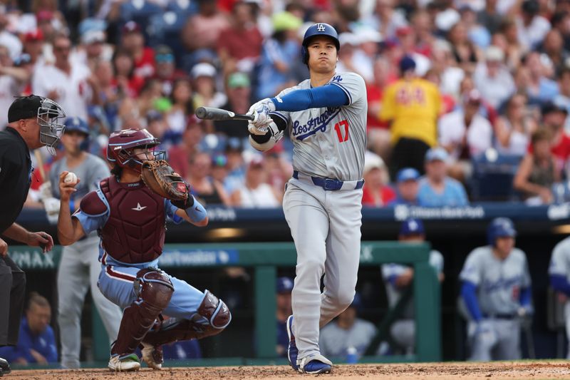 Jul 11, 2024; Philadelphia, Pennsylvania, USA; Los Angeles Dodgers Shohei Ohtani (17) strikes out in front of Philadelphia Phillies catcher Garrett Stubbs (21) during the fifth inning at Citizens Bank Park. Mandatory Credit: Bill Streicher-USA TODAY Sports