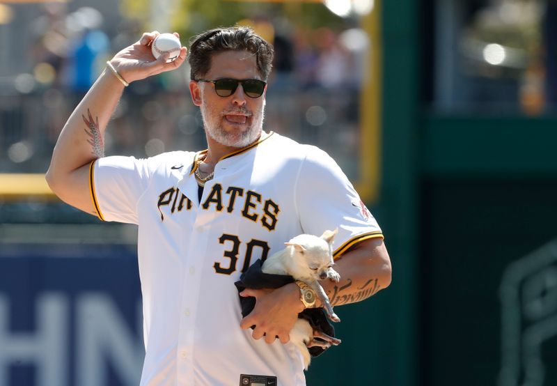 Aug 28, 2024; Pittsburgh, Pennsylvania, USA;  Motion picture and television actor Joe Maganiello throws out a ceremonial first pitch while holding his dog Bubbles prior to the Pittsburgh Pirates hosting  the Chicago Cubs at PNC Park. Mandatory Credit: Charles LeClaire-USA TODAY Sports