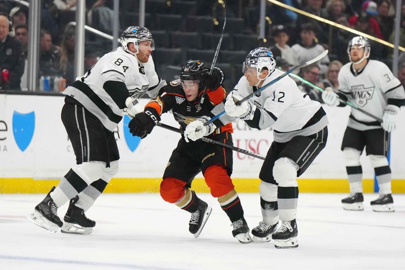 Apr 13, 2024; Los Angeles, California, USA; LA Kings defenseman Vladislav Gavrikov (84) and left wing Trevor Moore (12) defend against Anaheim Ducks defenseman Olen Zellweger (51)  in the third period at Crypto.com Arena. Mandatory Credit: Kirby Lee-USA TODAY Sports