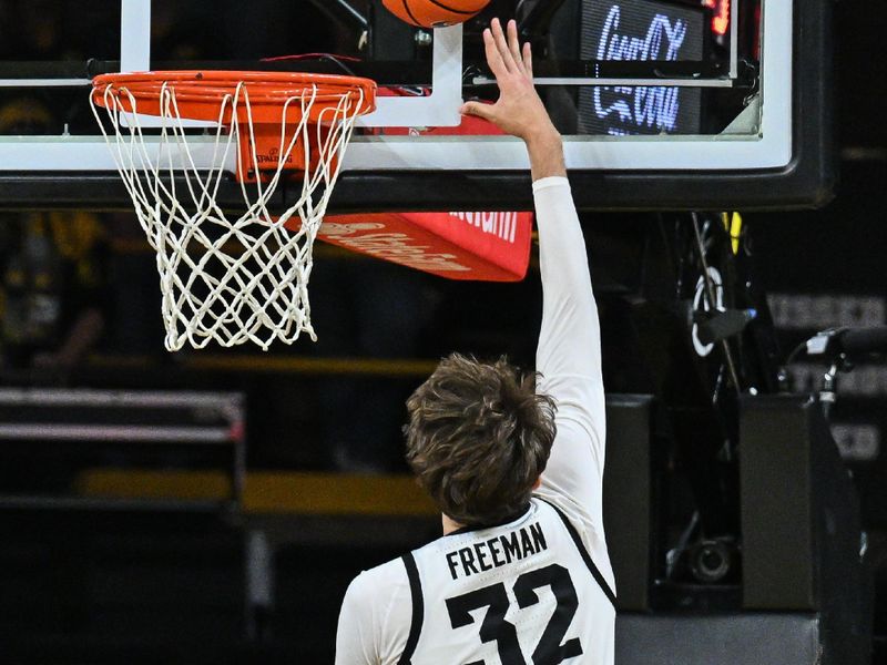 Jan 7, 2025; Iowa City, Iowa, USA; Iowa Hawkeyes forward Owen Freeman (32) goes to the basket as Nebraska Cornhuskers center Braxton Meah (34) looks on during the first half at Carver-Hawkeye Arena. Mandatory Credit: Jeffrey Becker-Imagn Images